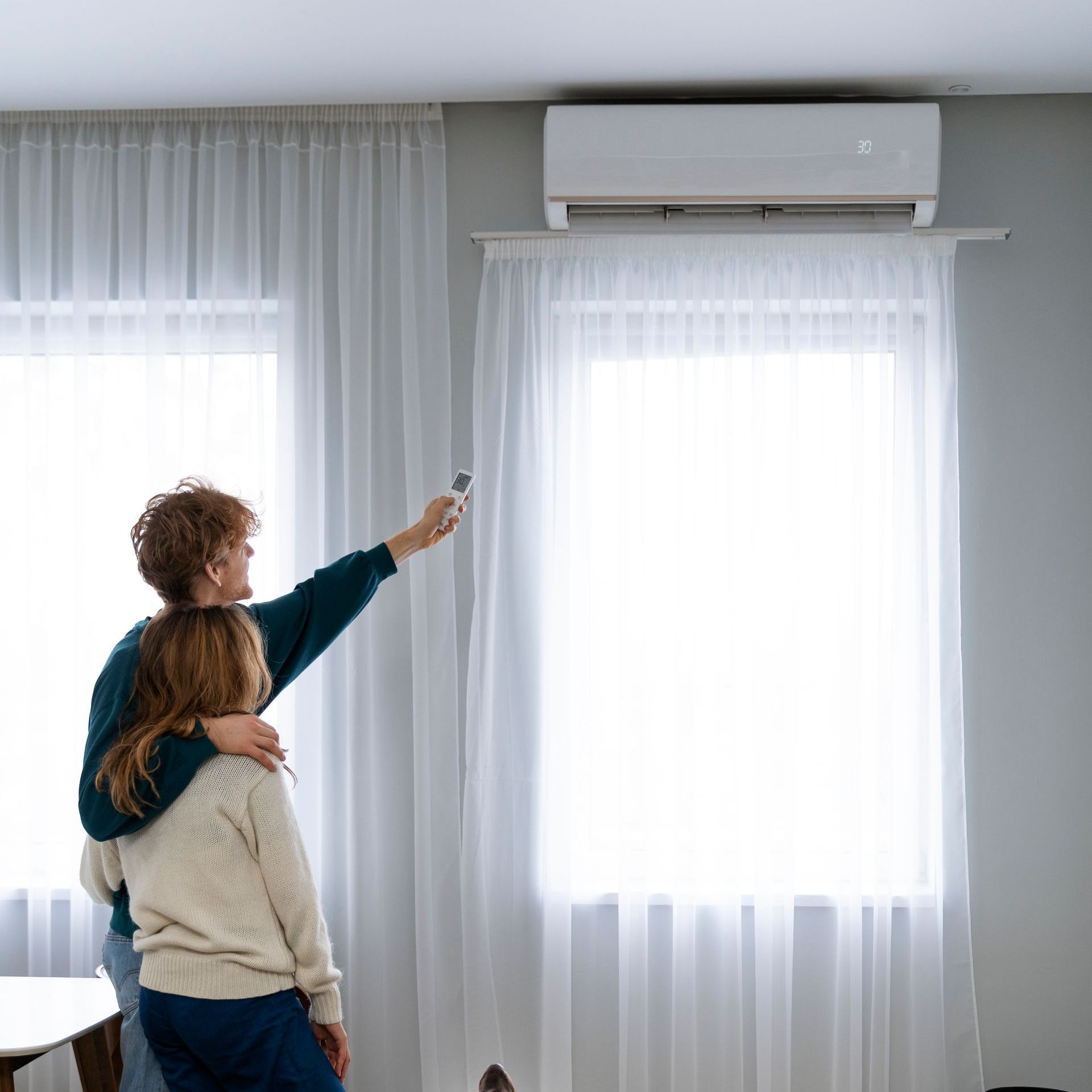 A white air conditioner is sitting on the side of a building.