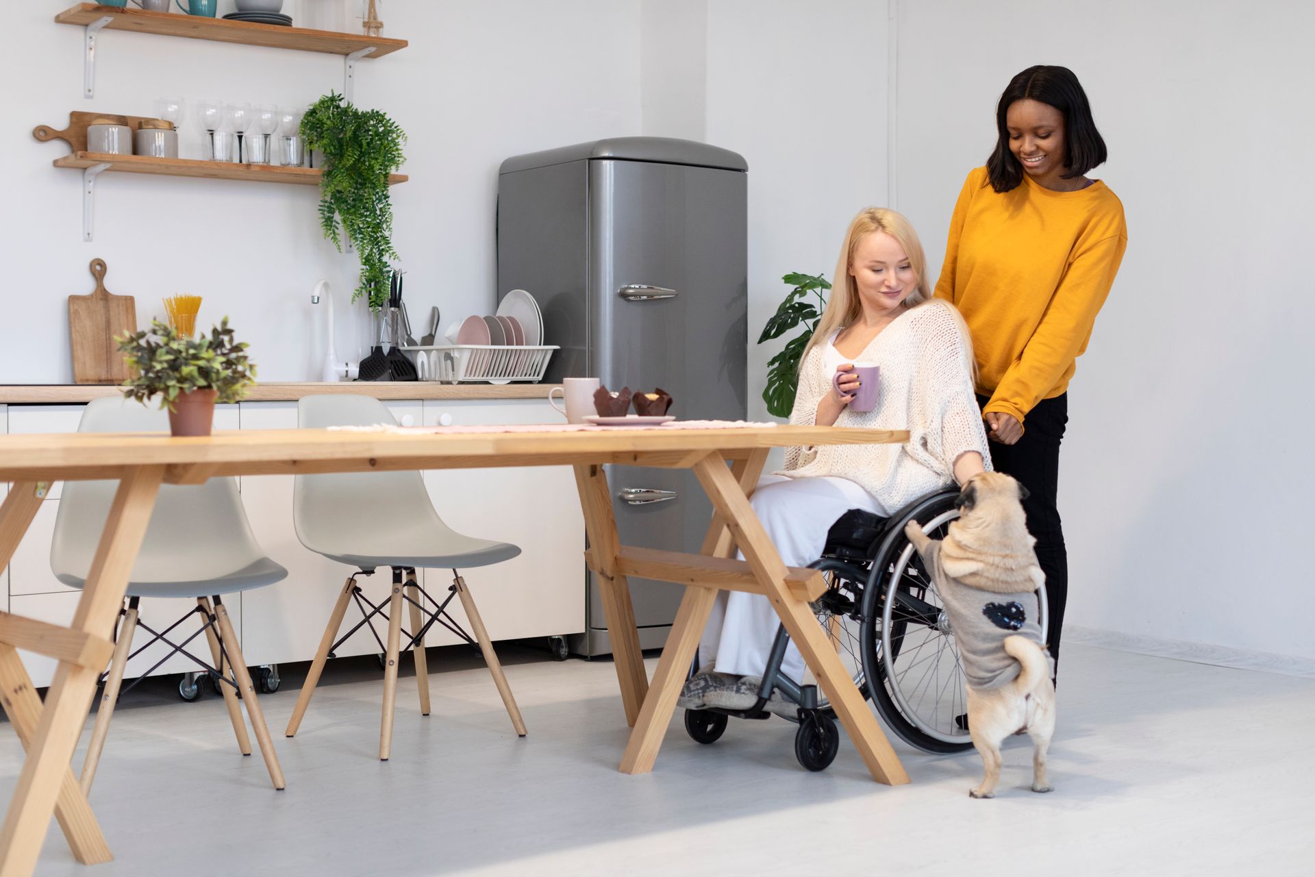 A woman in a wheelchair is sitting at a table with a dog.