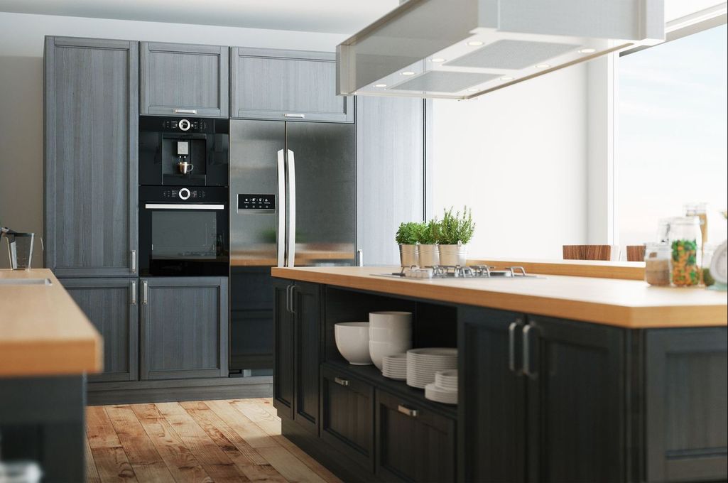 A kitchen with stainless steel appliances and wooden counter tops.