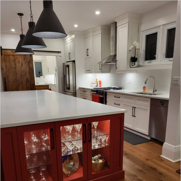 A kitchen with red cabinets and white counter tops