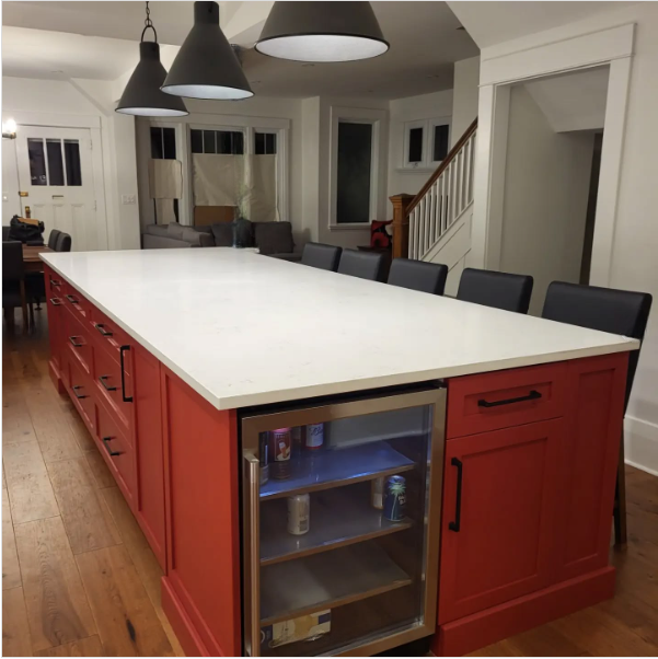 A kitchen with red cabinets and white counter tops