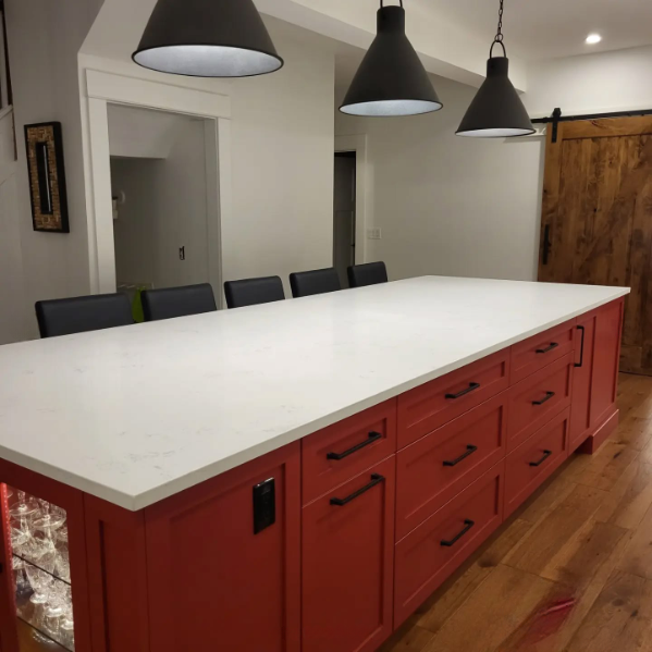 A kitchen with red cabinets and white counter tops