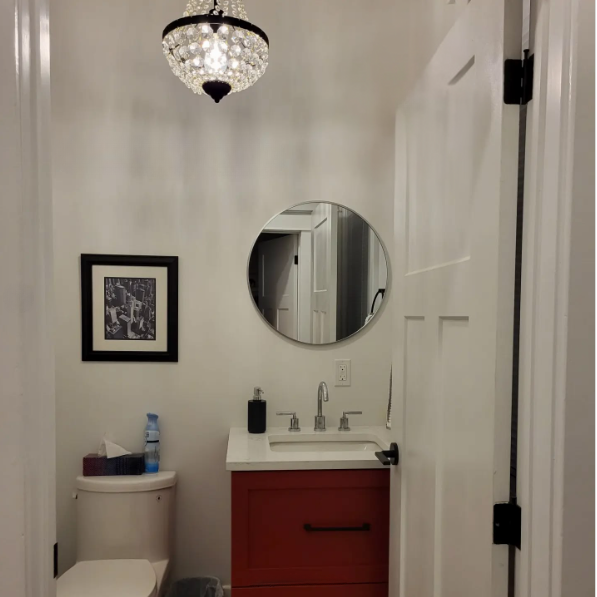 A bathroom with a toilet a sink and a mirror