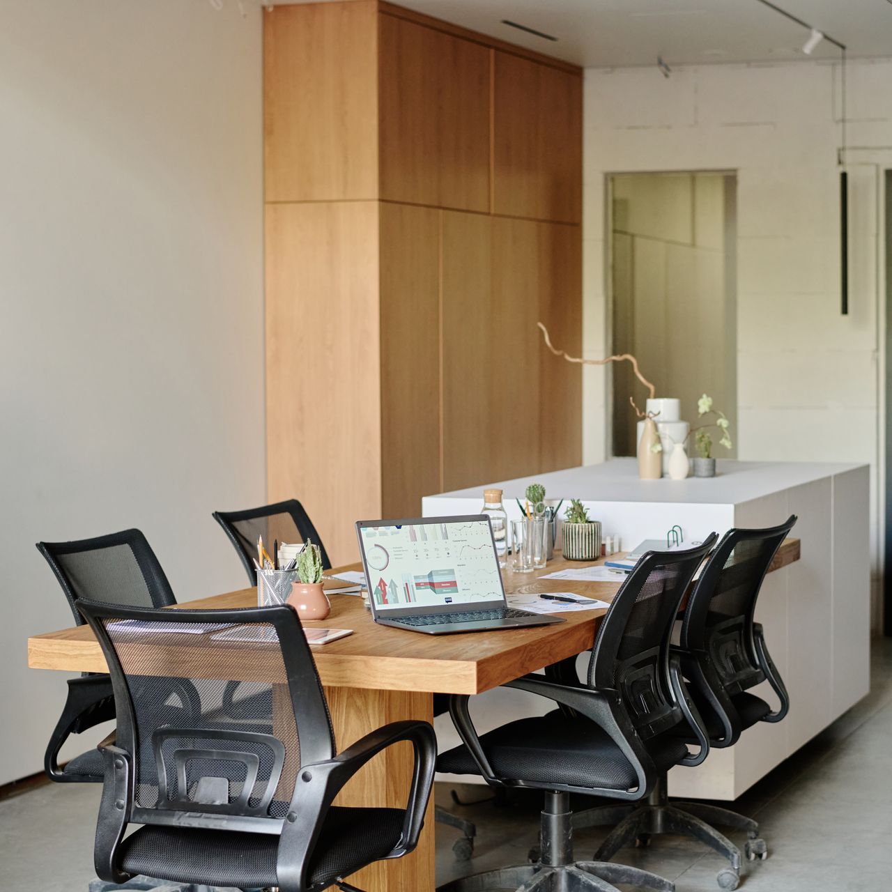 A conference room with a table and chairs and a laptop on it.