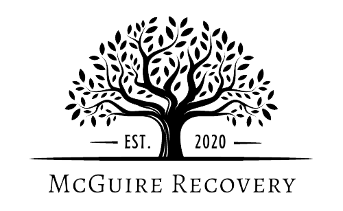 The logo for mcguire recovery has a tree with leaves on it.