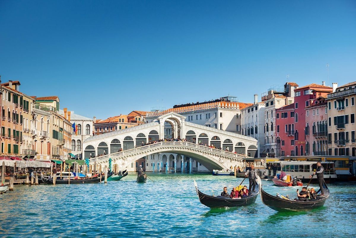 A couple of gondolas are floating on a river in venice.