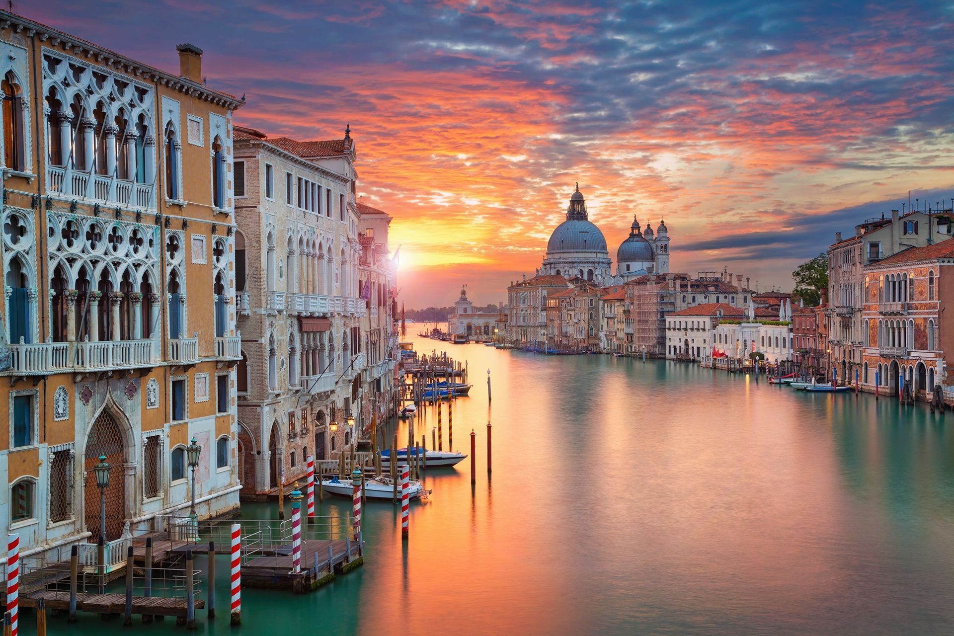 The sun is setting over the grand canal in venice.