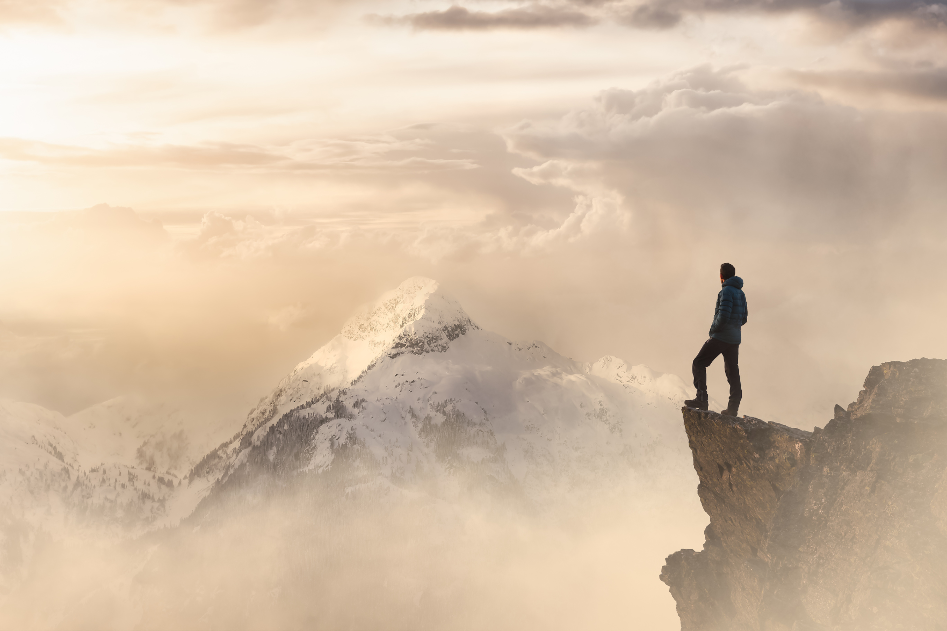 A man is standing on the edge of a mountain.