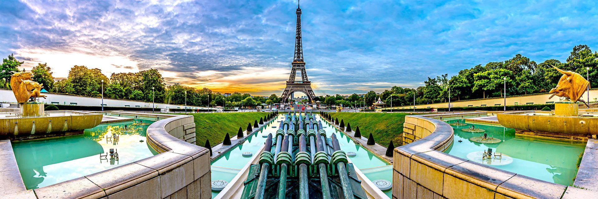 The eiffel tower is reflected in the water of a fountain in paris.