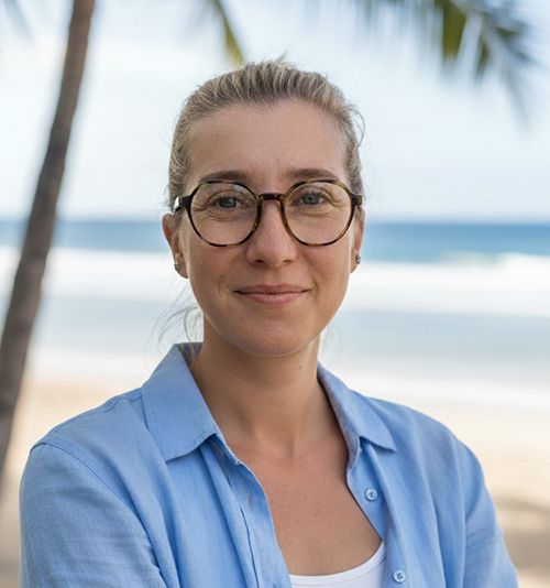 Hope with glasses smiles; tropical beach background.