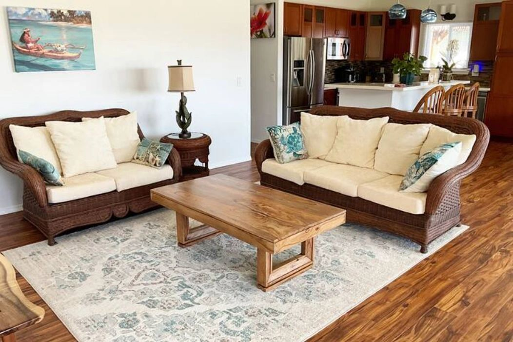 Living room with wicker sofas, wooden coffee table, and area rug.