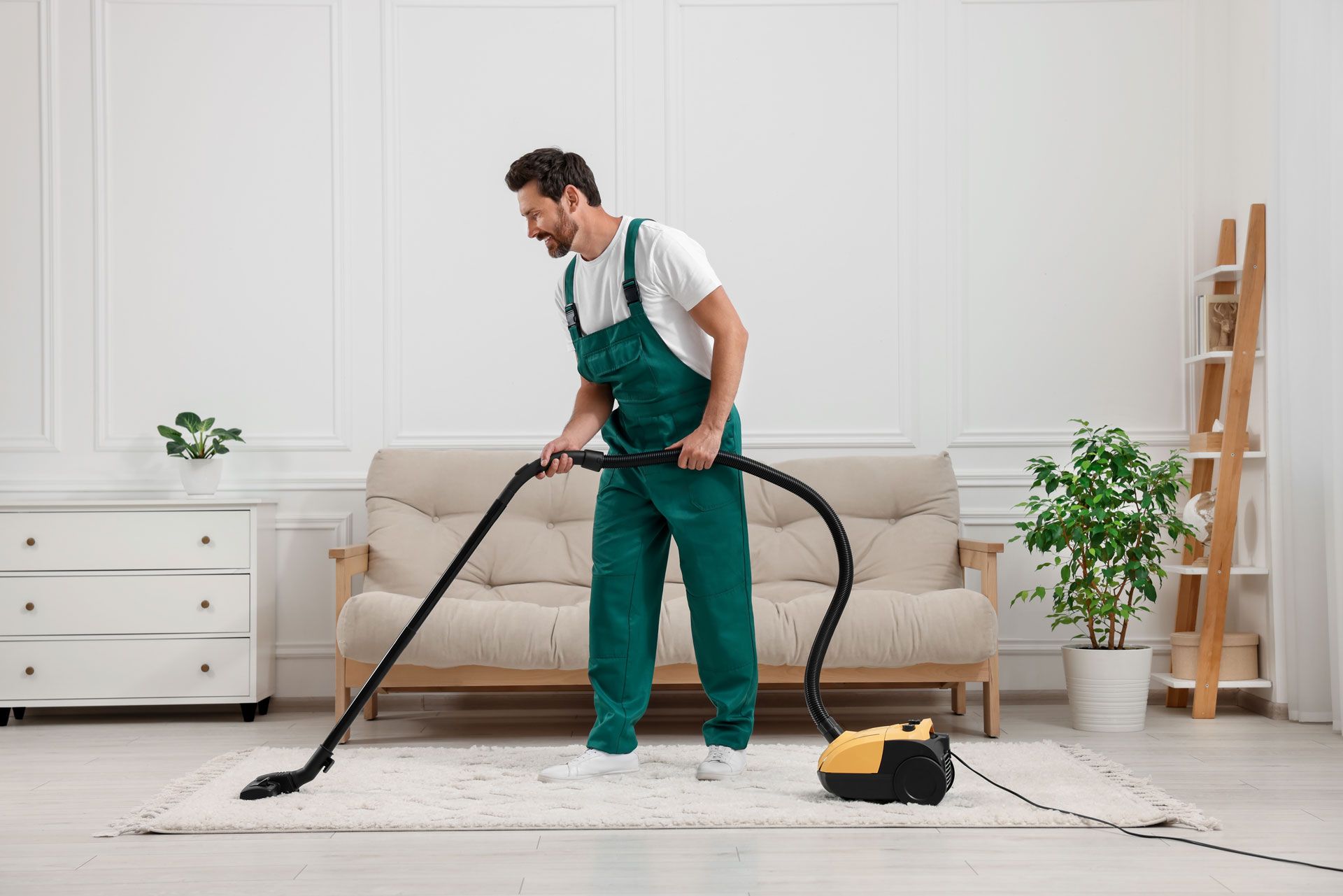 A man vacuuming a living room carpet, showcasing a tidy home and effective carpet cleaning.
