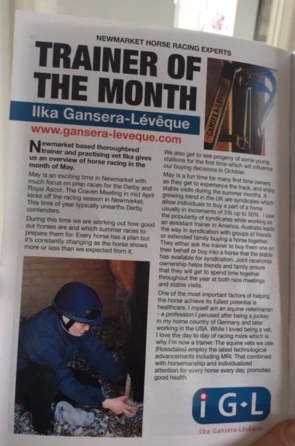 A magazine is open to a page that says trainer of the month