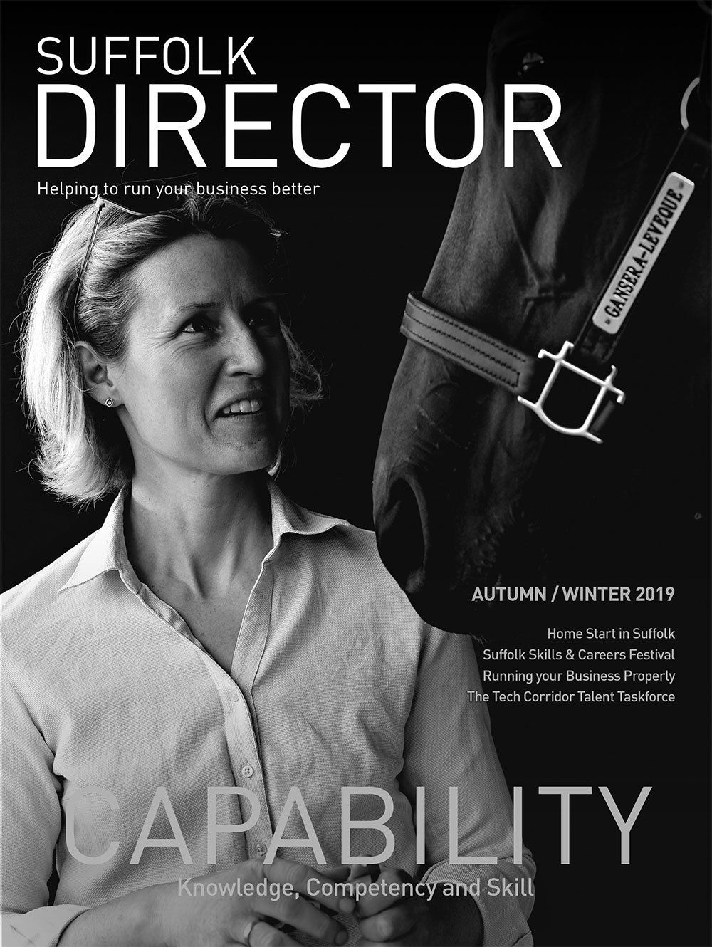 A black and white photo of a woman standing next to a horse.