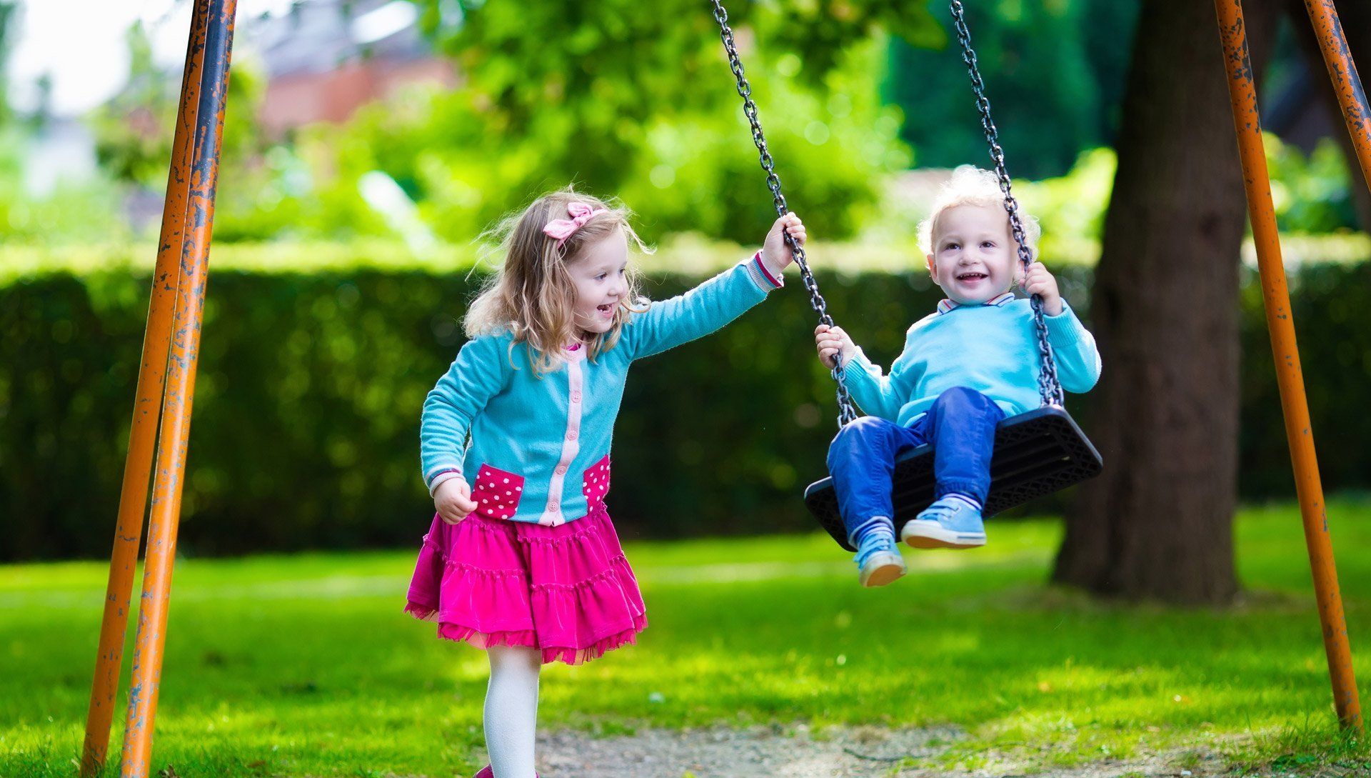 young children playing on swings outside