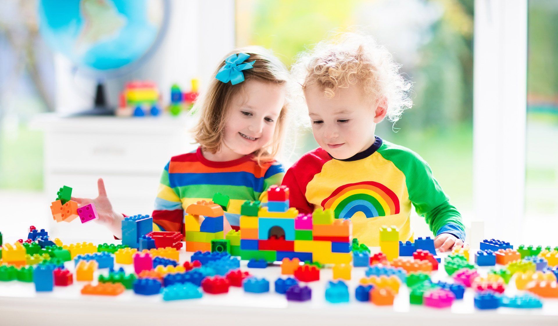 two young children play with building blocks
