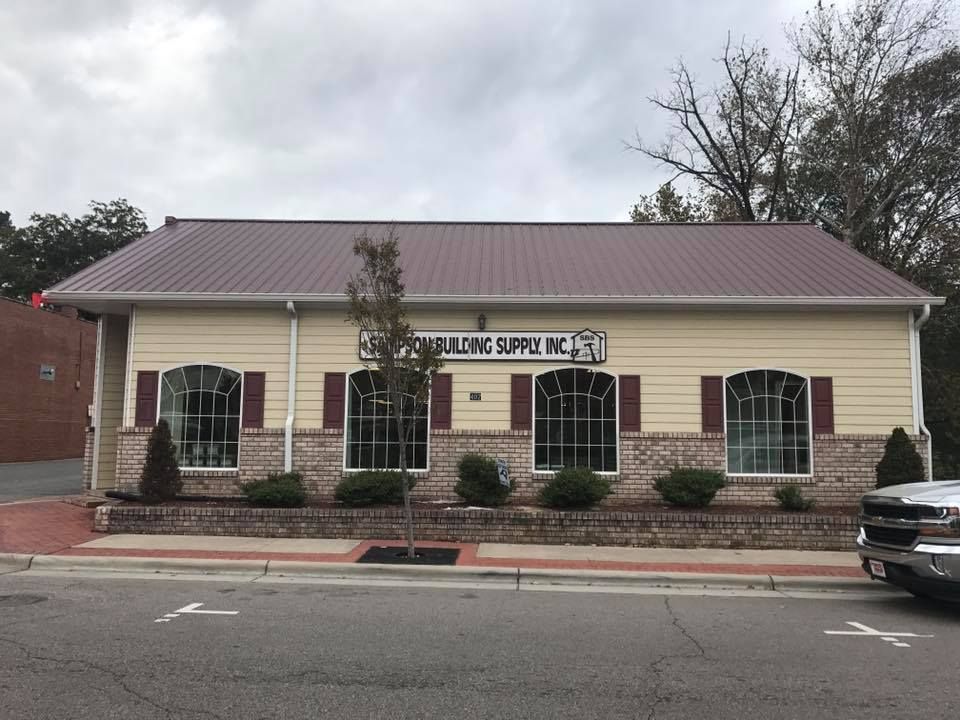 A building with a red roof and a sign that says building supplies