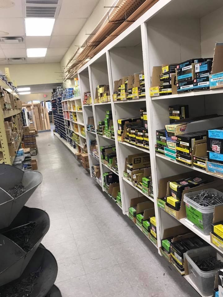 A store aisle filled with shelves filled with boxes of nails.