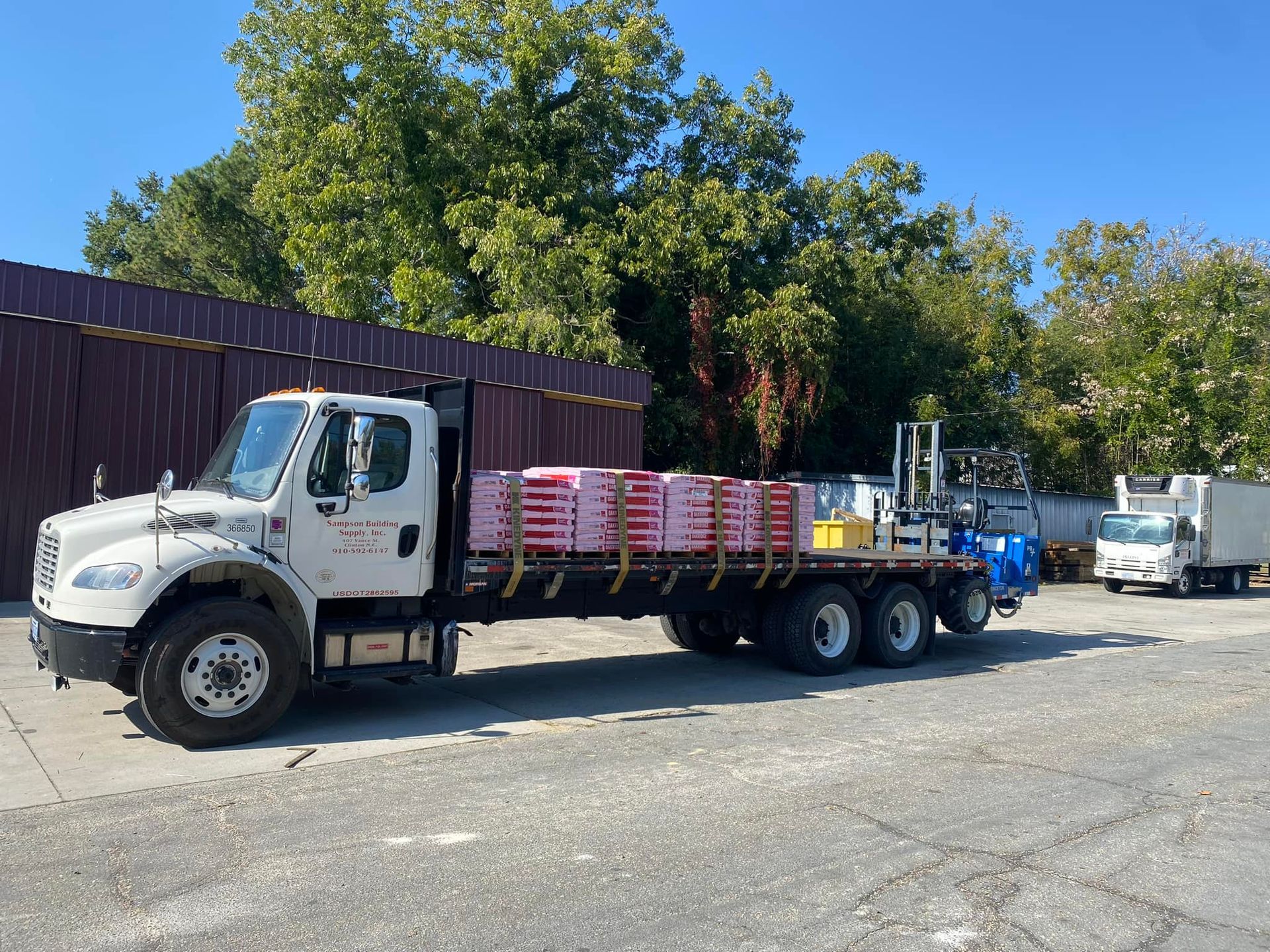 A white truck is parked in a parking lot filled with bricks.