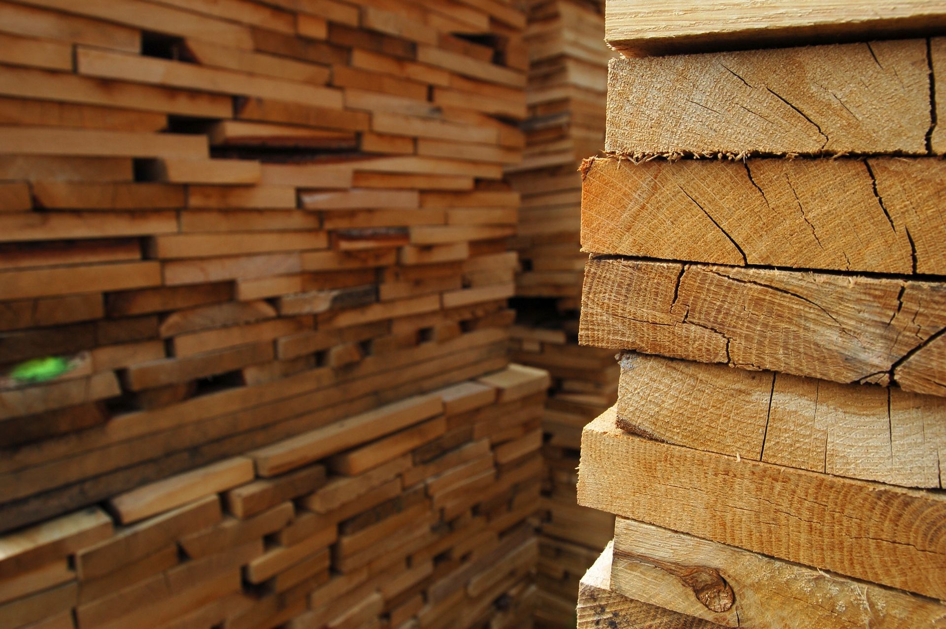 Stack of cut lumber with visible wood grain and cracks.