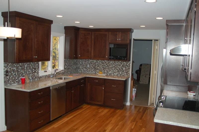 Modern kitchen with dark wood cabinets, mosaic tile backsplash, and hardwood floors