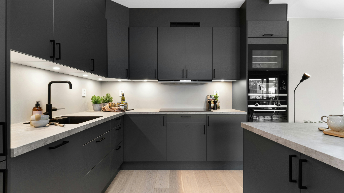 Modern black-and-white kitchen with sleek cabinets, under-cabinet lighting, and built-in appliances.