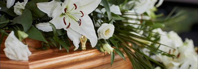 Image of white flowers on a light coloured coffin