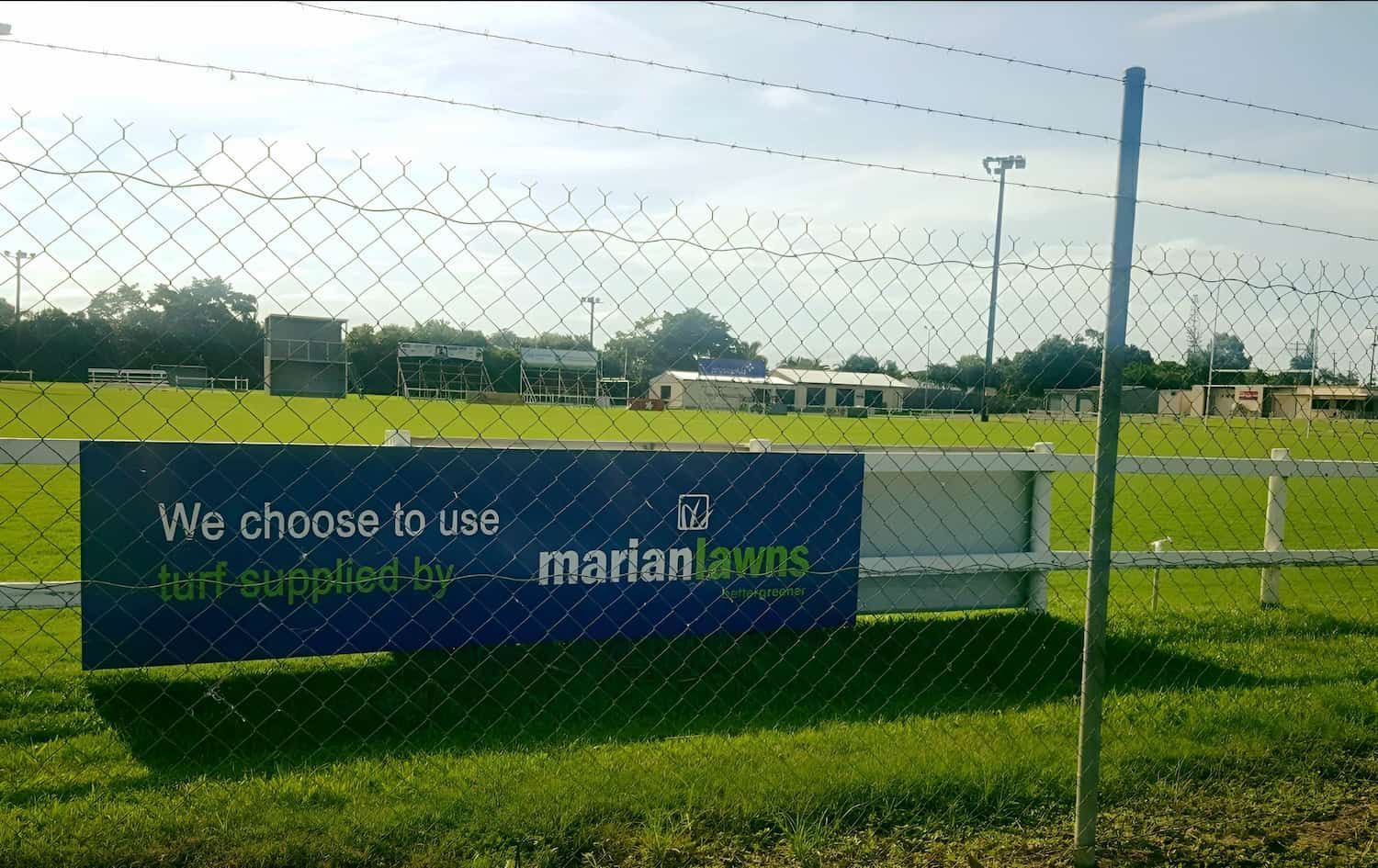 A Sign Behind A Chain Link Fence Says We Choose To Use Marianlawns — Marian Lawns In Marian, QLD