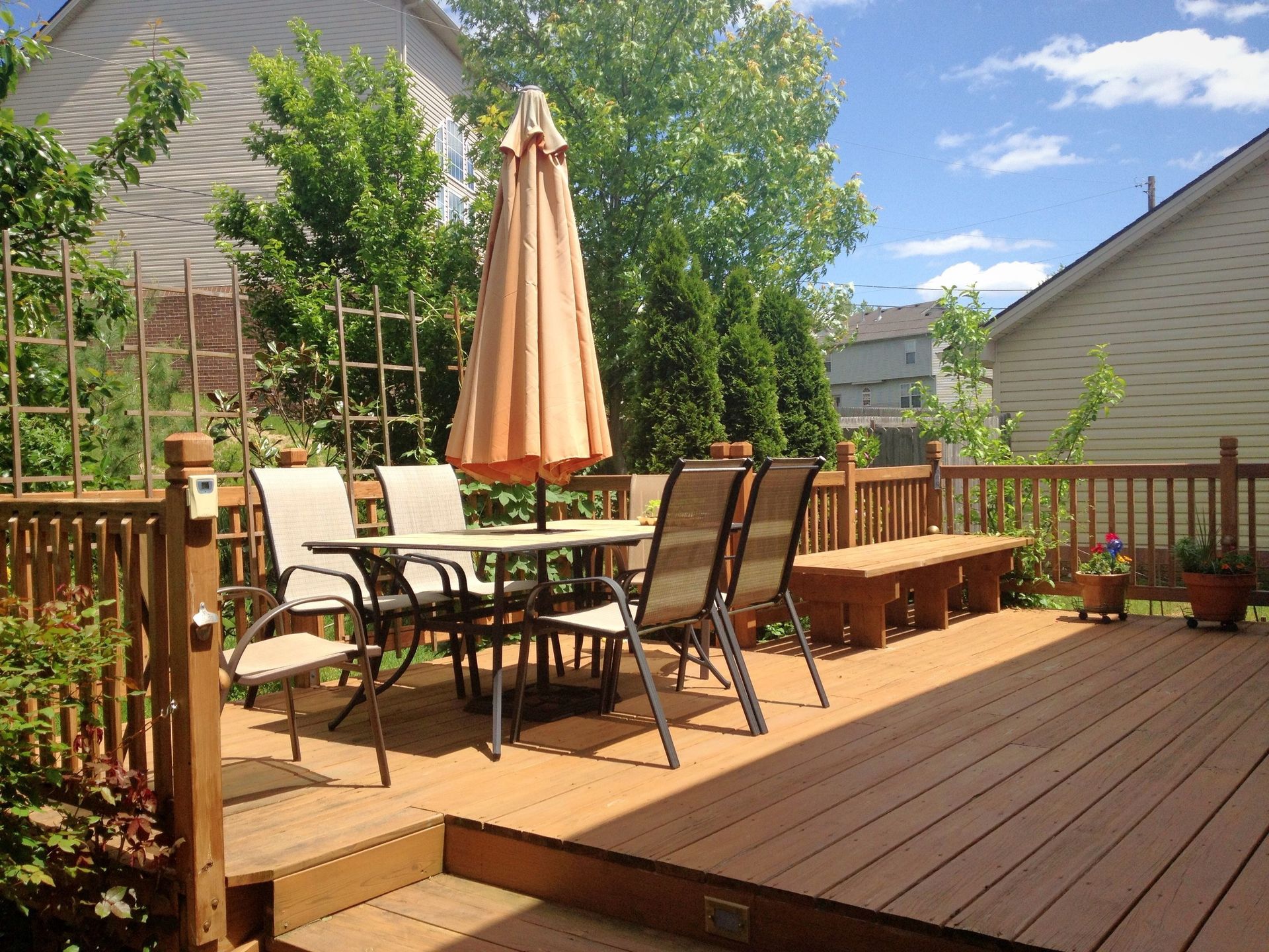 A lush, vibrant summer garden with a wooden deck.