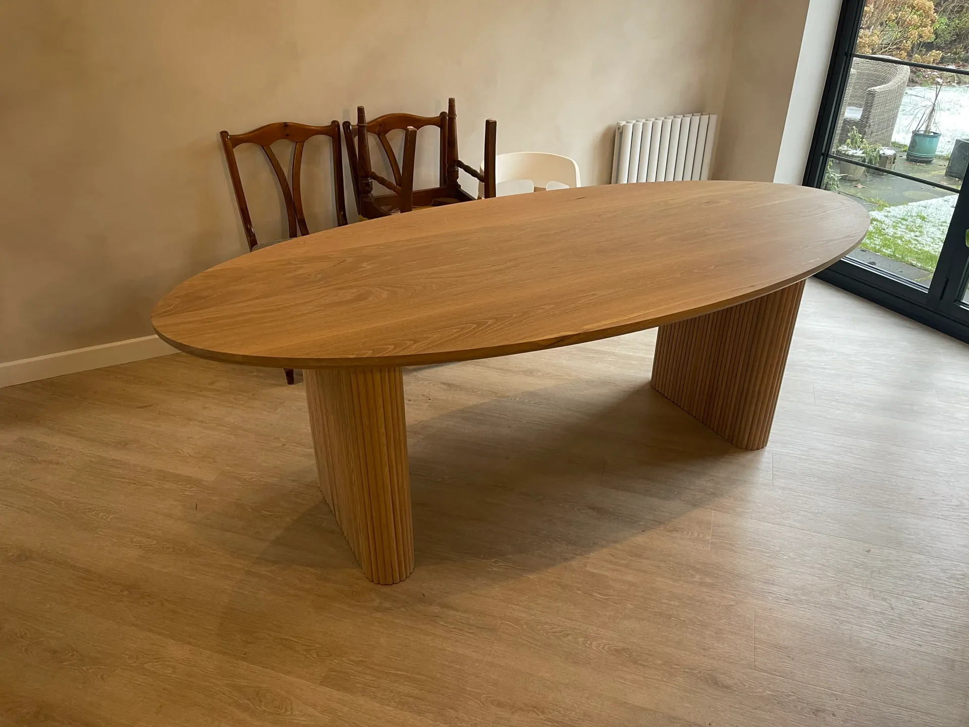 A hardwood oval table with elegant grain patterns and a polished finish.