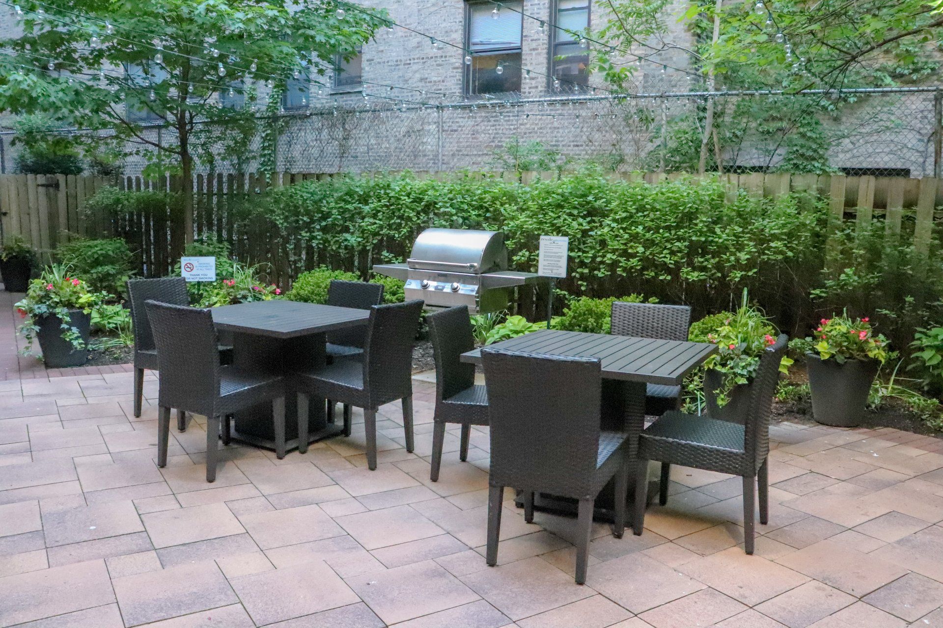 Apartment outdoor patio with tables and chairs and a grill at Reside at 849.