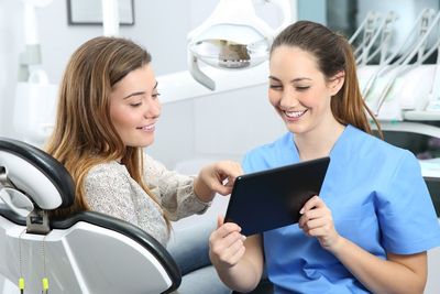 Cosmetic Dentistry — Dentist with Medical History Asking to a Patient in Cumming, GA