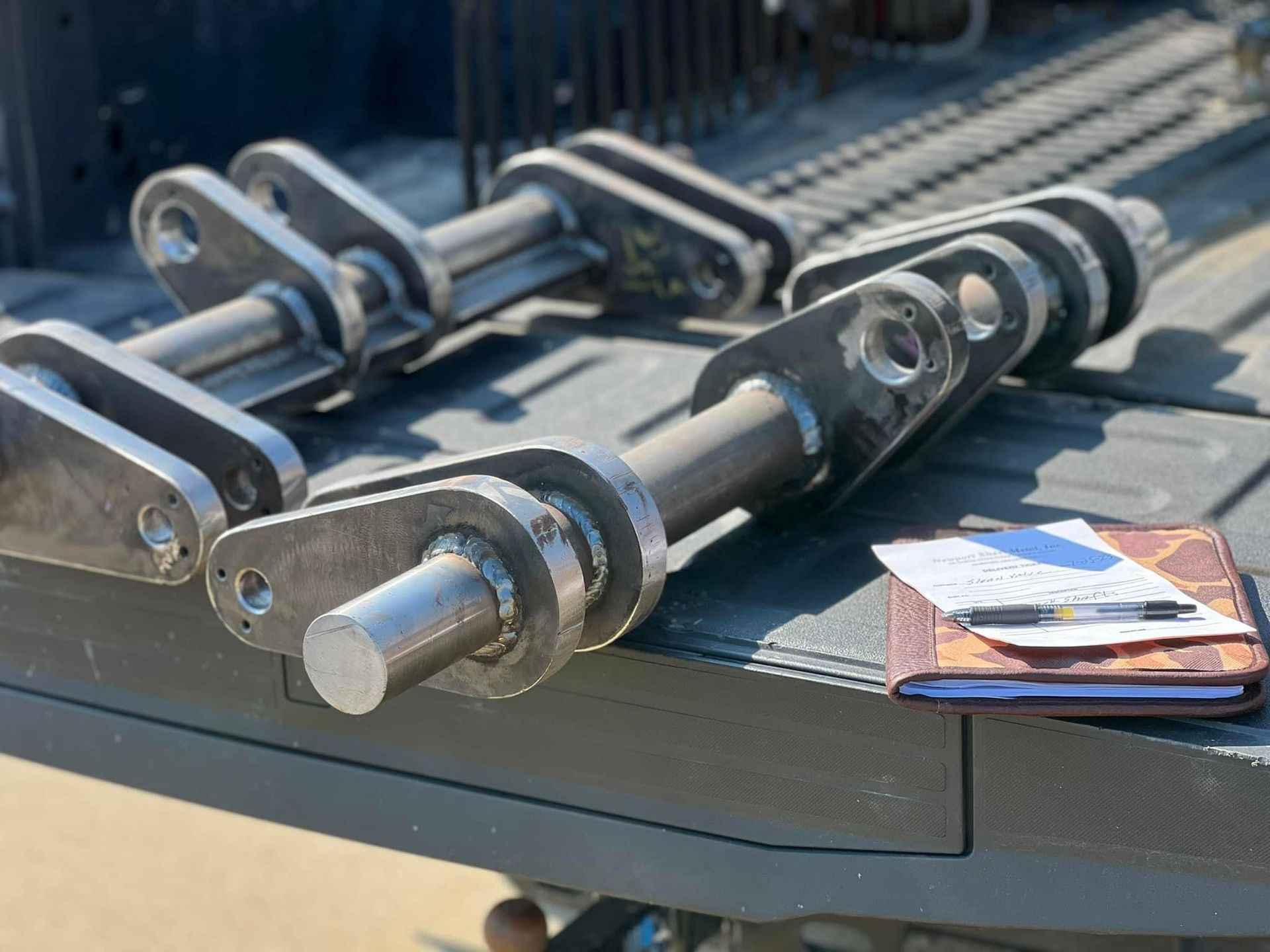 a piece of metal is sitting on a table next to a notebook and pen .