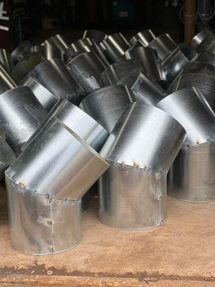 a bunch of metal pipes are stacked on top of each other on a table .