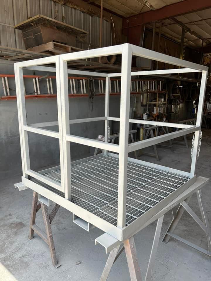 a metal cage is sitting on top of a wooden trestle .