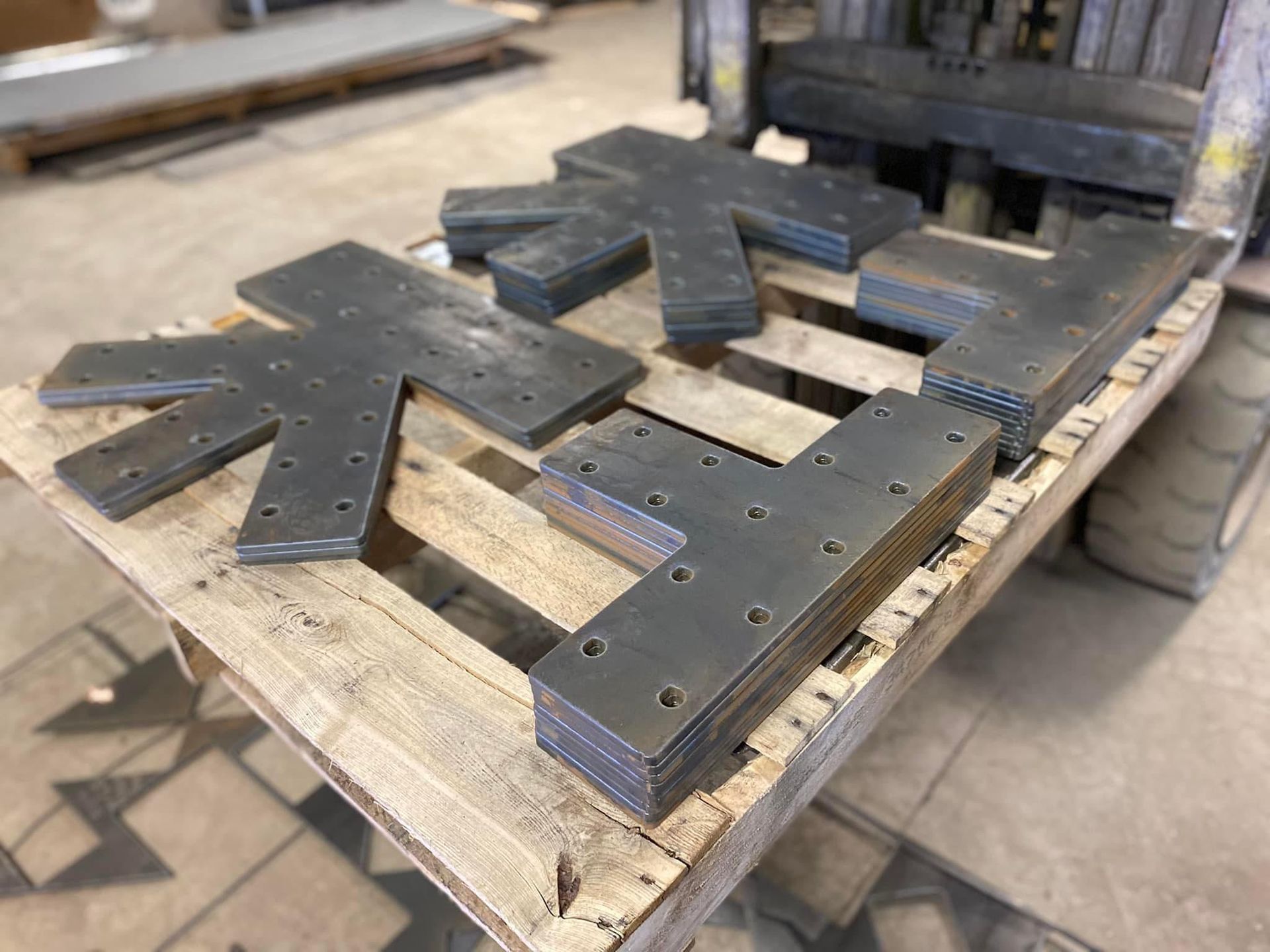 a wooden pallet with a bunch of metal pieces on it