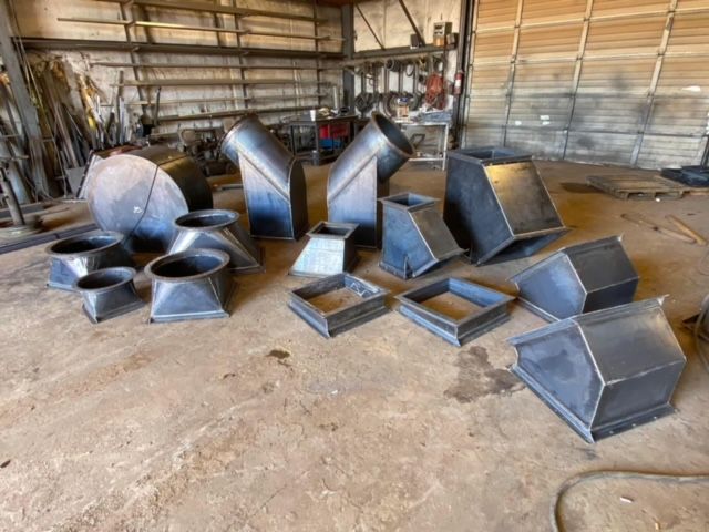 a bunch of metal pipes are sitting on the ground in a workshop .