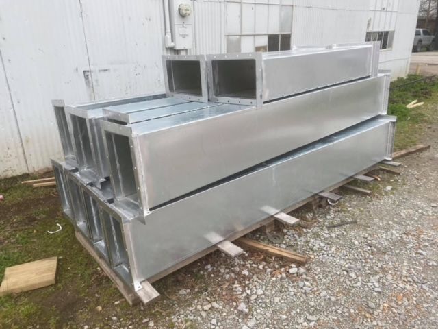 a stack of metal pipes sitting on top of each other on a gravel road .