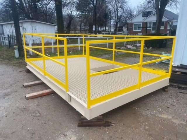 a wooden platform with a yellow railing on it