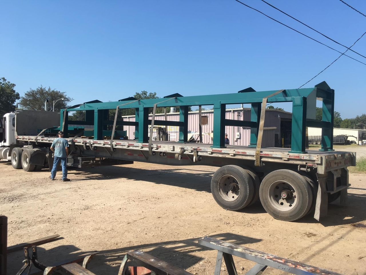 a truck is carrying a large green structure on the back of it