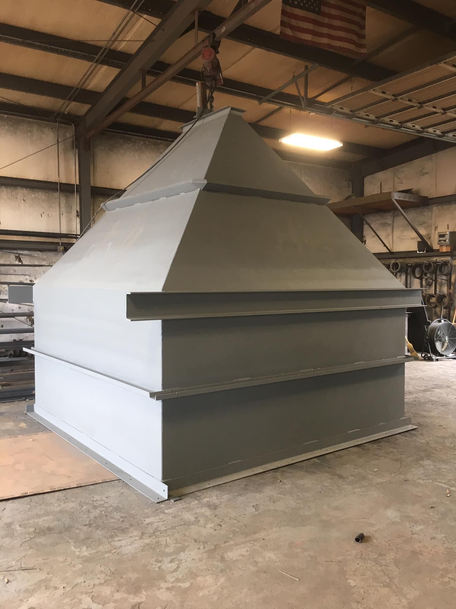 a large gray box is sitting in a room with an american flag hanging from the ceiling