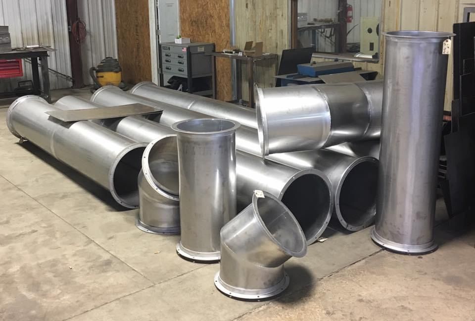 a bunch of metal pipes are sitting on the floor in a room .