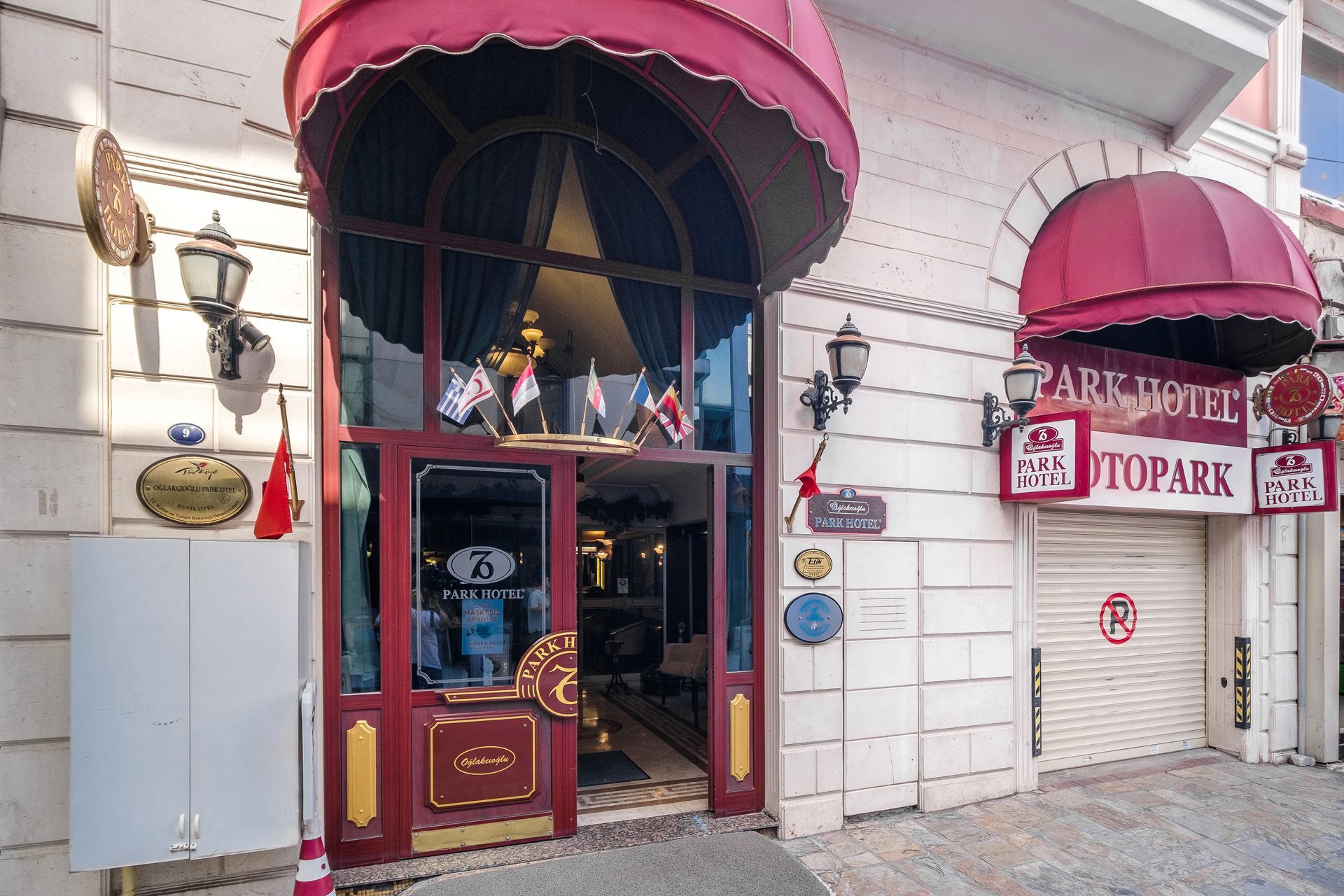 A building entrance with a red awning and glass doors next to a closed storefront labeled 