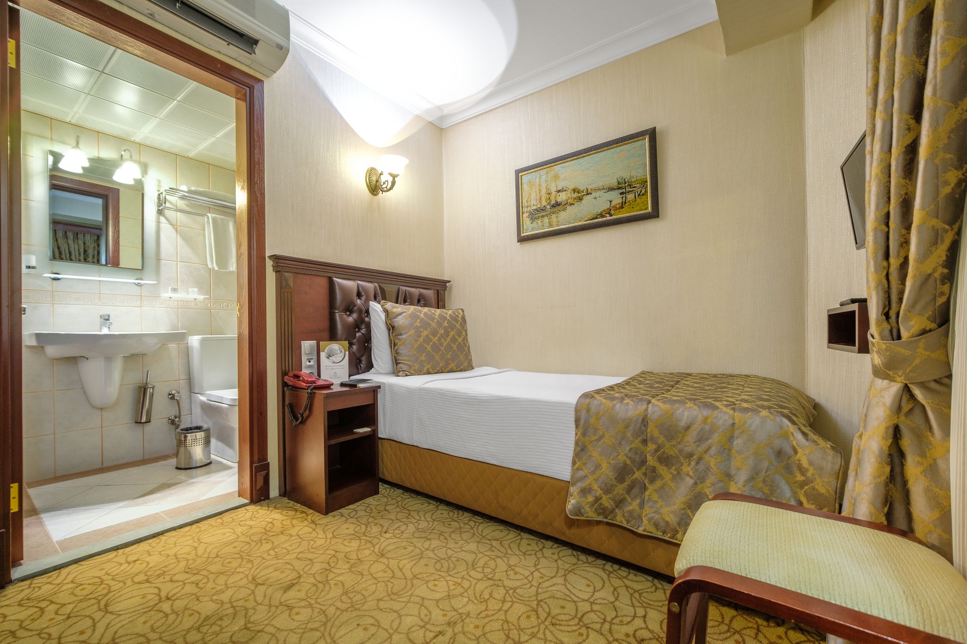 Park Hotel's room with a single bed, a small nightstand, and an adjoining bathroom featuring a sink, toilet