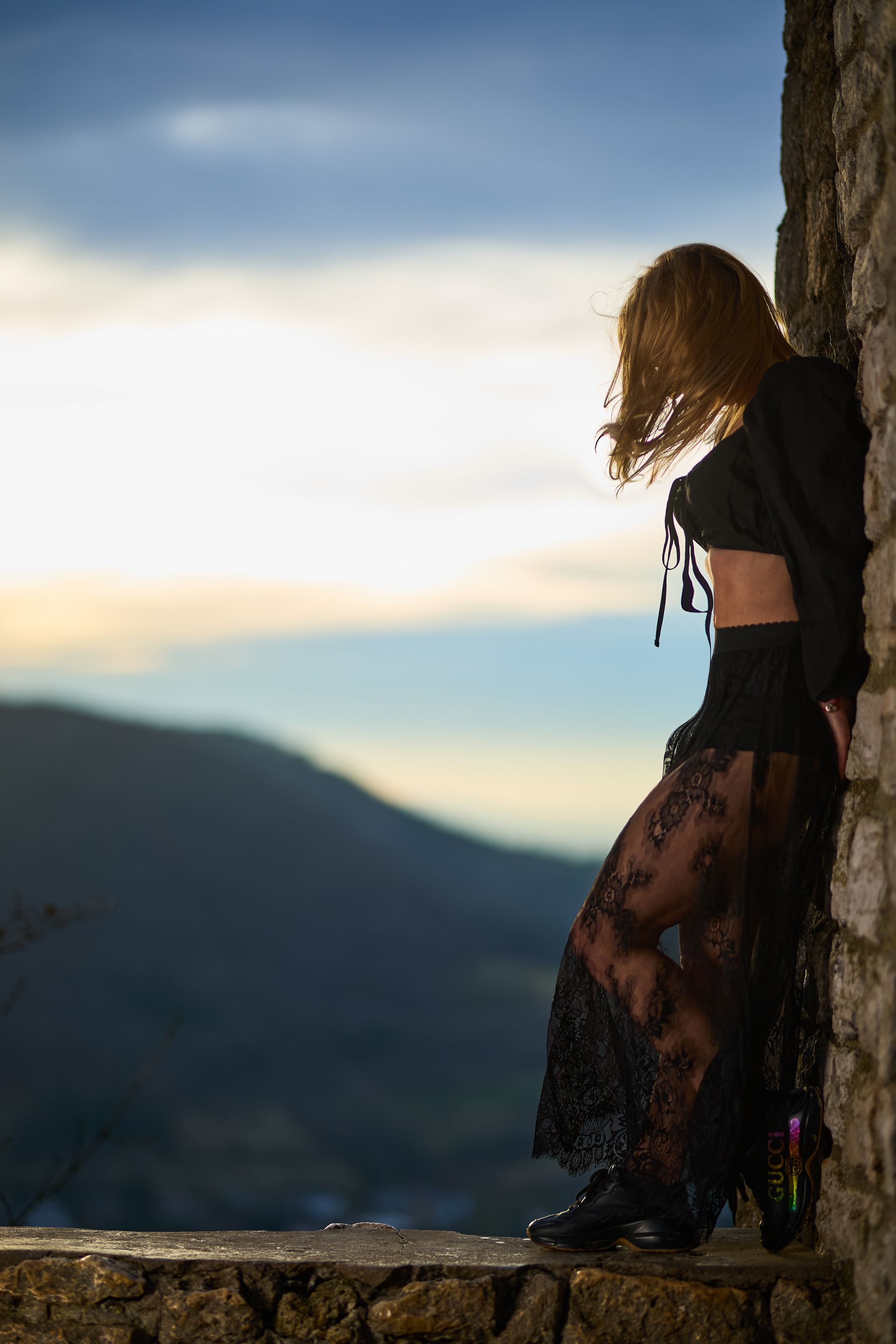 Anastasia lehnt sich an einen Felsen