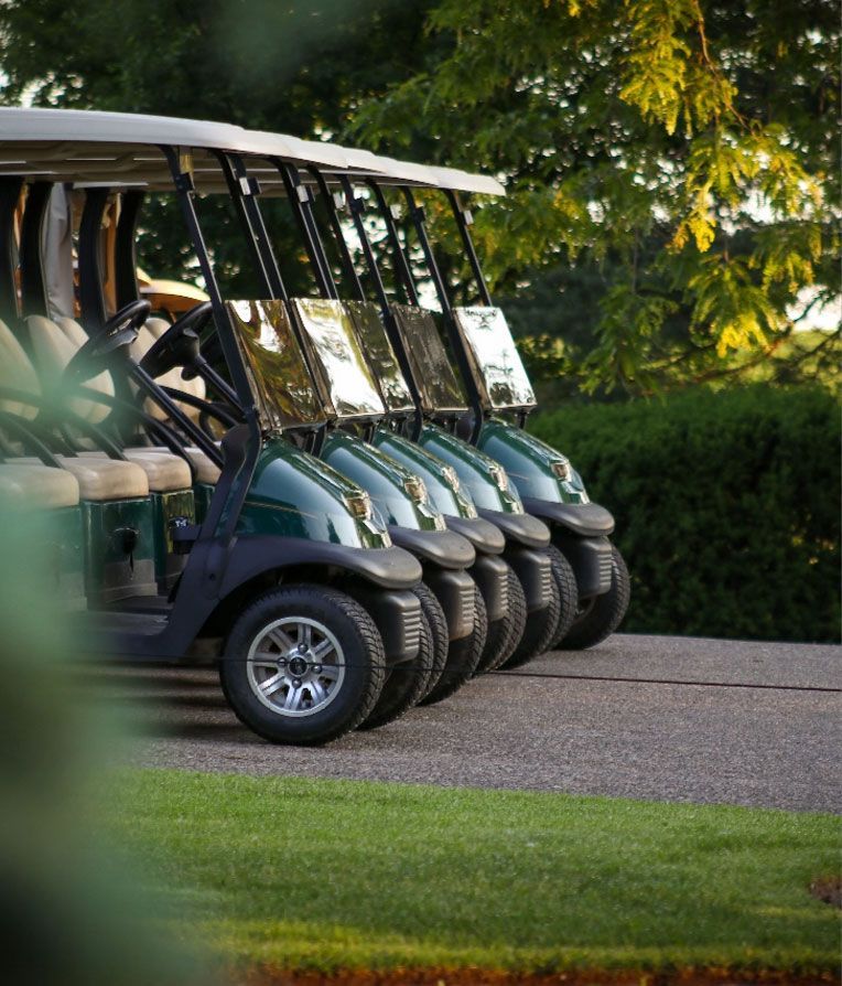 A row of golf carts are parked next to each other