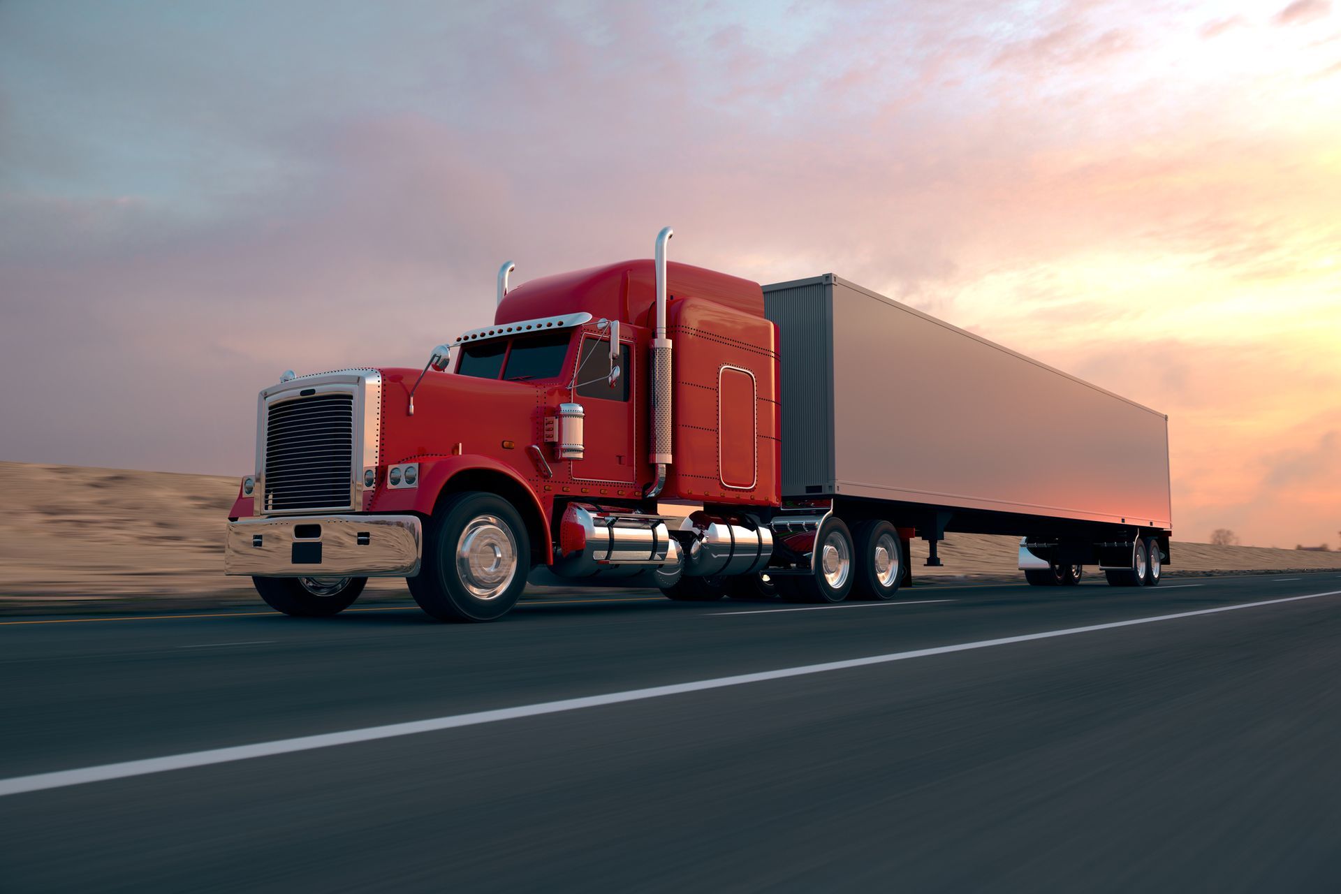 A red semi truck is driving down a highway at sunset.