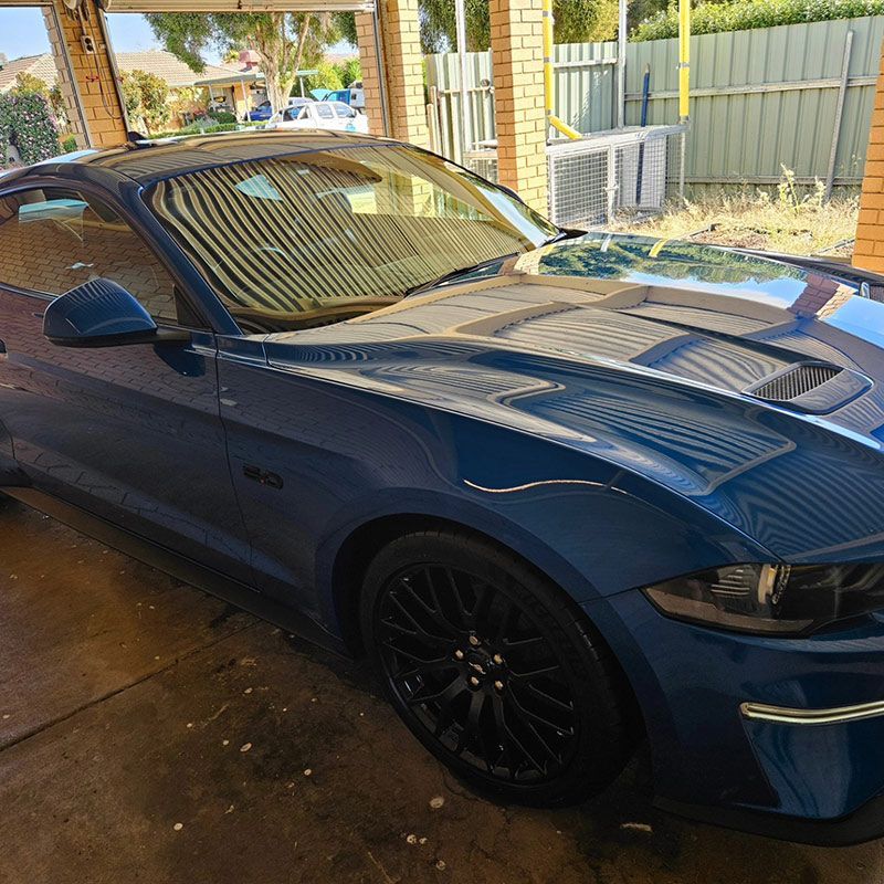 A Blue Mustang Is Parked Beneath A Canopy In A Parking Lot — On Point Detailing Wagga in East Wagga Wagga, NSW