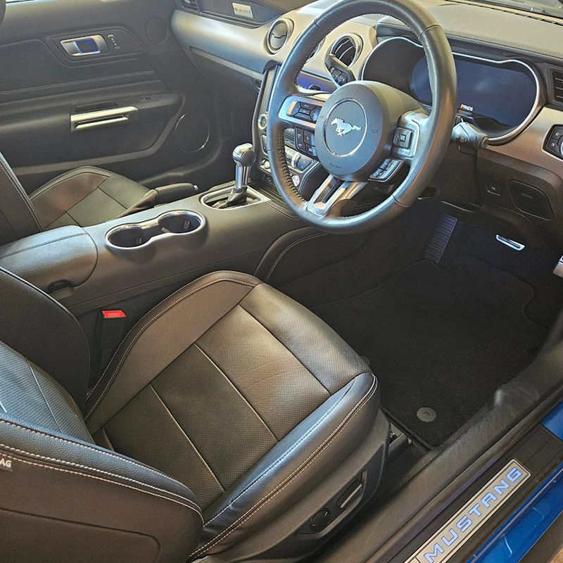 The Interior Of A Blue Mustang With Black Leather Seats And A Steering Wheel — On Point Detailing Wagga in East Wagga Wagga, NSW
