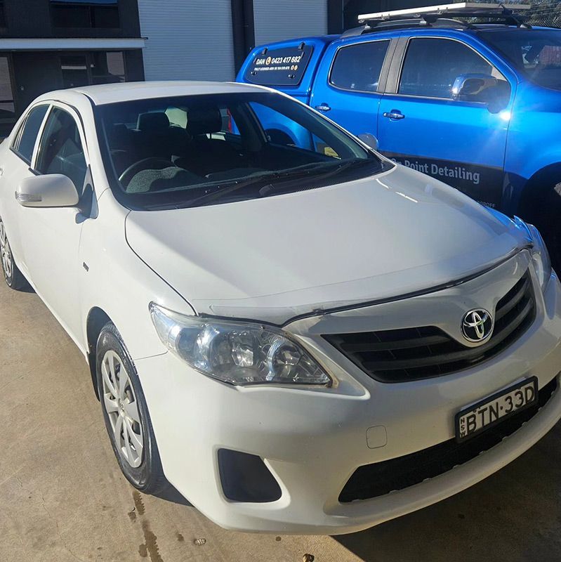 A White Car Is Parked Next To A Blue Truck — On Point Detailing Wagga in East Wagga Wagga, NSW